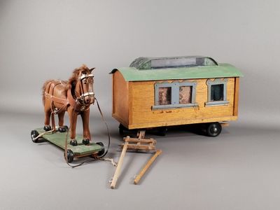 un cheval en jouet tirant une charrette à laquelle est attaché un autre cheval