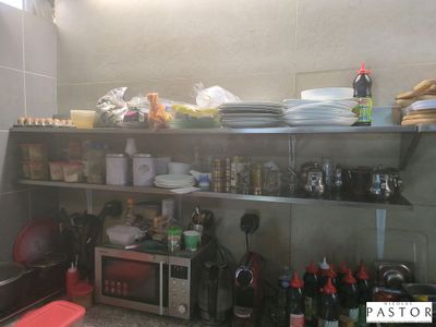 une petite cuisine avec beaucoup de vaisselle sur les étagères