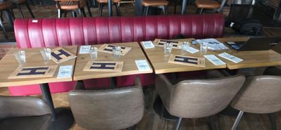 tables and chairs in a restaurant with red booths and wooden tables