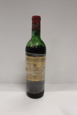 an old bottle of wine sitting on top of a white table