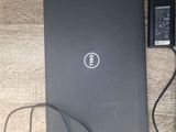 dell laptop with charger and power cord on a wooden table