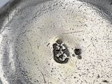 a close up of a silver plate with a hole in it