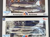 deux boîtes contenant des maquettes d'avions d'American Airlines posées sur une table