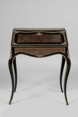 une petite table noire et dorée avec un tiroir sur le dessus