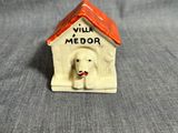 une figurine représentant un chien assis dans une niche