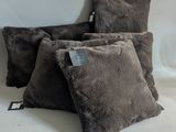three brown pillows sitting on top of a white table