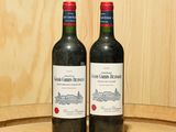 deux bouteilles de vin posées sur un tonneau