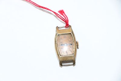 une petite montre-bracelet en or entourée d'un cordon rouge