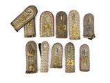 six pairs of military badges with numbers on them on a white surface