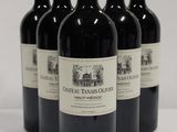 four bottles of red wine are lined up on a white surface