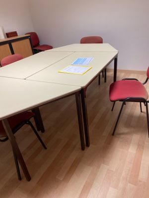 une table et des chaises dans une pièce avec du parquet