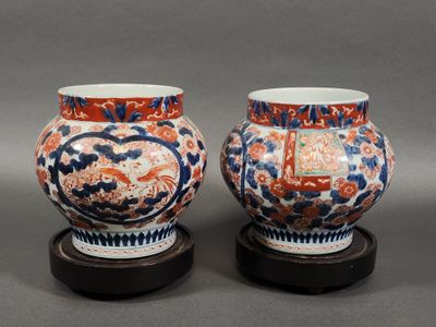 une paire de vases chinois posés sur des socles, sur un fond gris