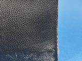 an old black leather purse with a metal clasp on a blue background