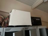 a white microwave sitting on top of a metal shelf