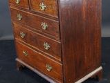 an antique wooden chest of drawers with brass pulls