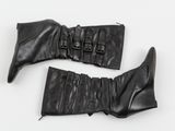 une paire de bottes en cuir noir posées sur une surface blanche