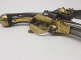 brass plated pistol with black and gold accents on a white surface