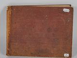 an old book sitting on top of a table next to a white wall