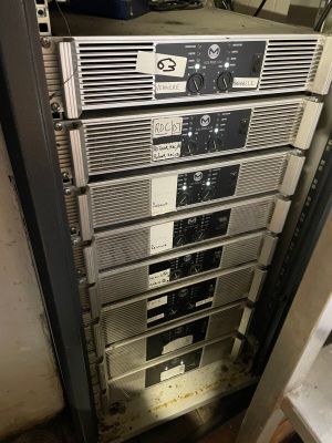 a rack of electronic equipment in the corner of a room