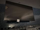 une télévision à écran plat fixée au mur au-dessus d'un casier à vin