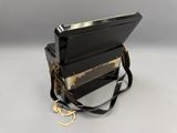 a black purse that is sitting on top of a white table