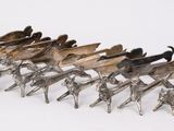 a group of metal horses that are standing in a row