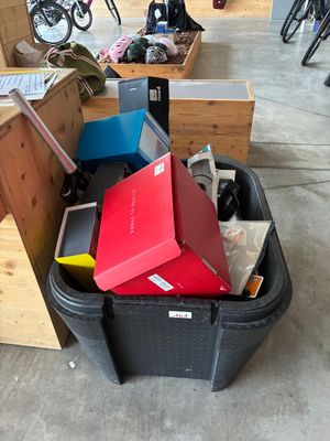 a bin full of boxes and a laptop on the floor