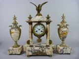 une horloge en marbre et trois vases surmontés d'un oiseau