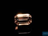 un gros plan d'un diamant posé sur une surface noire, avec un fond noir