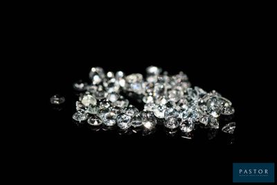 a close up of a pile of diamonds on a black surface