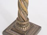 bronze statue of a woman holding a flower on a pedestal