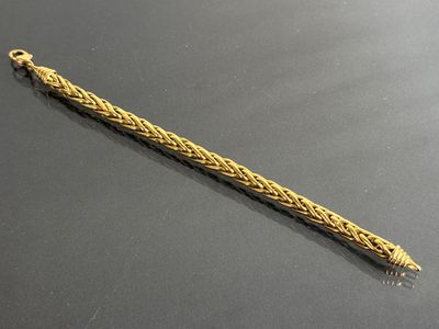 an image of a gold bracelet with a braid design on it