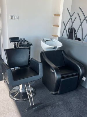 une chaise noire et un lavabo blanc dans une pièce
