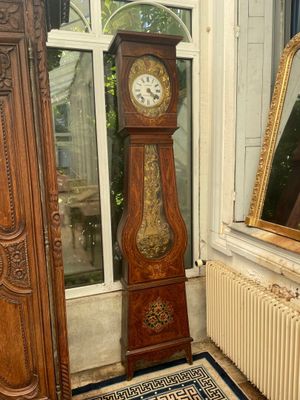 a grandfather clock in the corner of a room next to a radiator