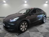 La Tesla Model Y est garée sur un sol en carrelage à damier.