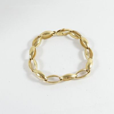 a close up of a gold bracelet on a white surface