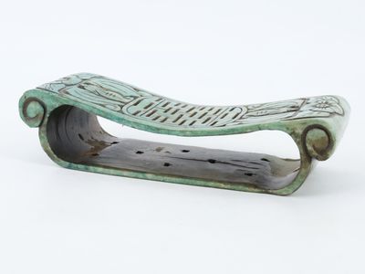 un petit objet vert posé sur une surface blanche