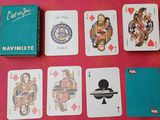 Des cartes à jouer sont disposées sur une table, à côté d'une boîte de cartes à jouer