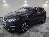 a black nissan suv parked on a checkered floor in a garage