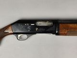 a close up of a shotgun with a wooden handle on a white surface