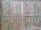 une image représentant un tissu à motifs paisley colorés sur fond noir