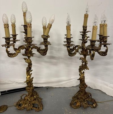 pair of antique brass candelabs with candles on each of them