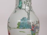 a white vase with a painting on it sitting on a table