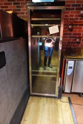 une personne se tenant dans un ascenseur, avec une pancarte accrochée à la porte
