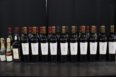 Des bouteilles de vin sont alignées sur une table devant un fond noir.