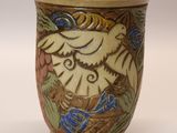 a vase with a bird on it sitting on a table