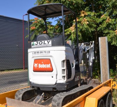 a small excavator on the back of a trailer