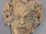 une image représentant une sculpture du visage d'un homme sur un mur