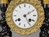 a black and gold clock sitting on a stand