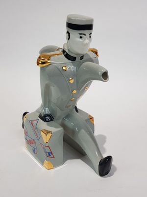 a figurine of a man sitting on top of a suitcase